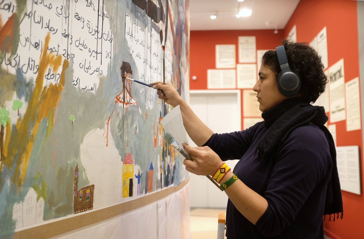 Die Künstlerin Hanaa El Dagham während ihrer Arbeit am Wandgemälde „Die Wiedergeburt des Osiris" in der Dauerausstellung BERLIN GLOBAL
